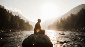 Pessoa meditando em silêncio ao nascer do sol, simbolizando o despertar interior e a prática do Budismo como filosofia de vida.