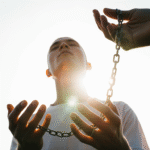 Mãos soltam correntes na luz do sol, transmitindo sensação de libertação espiritual íntima